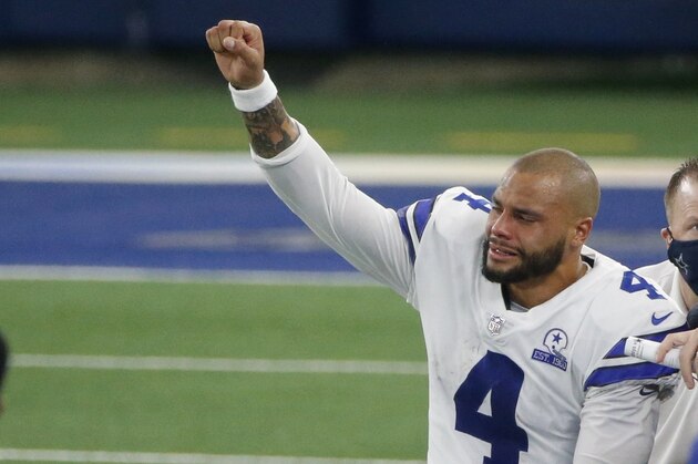 Dallas Cowboys quarterback Dak Prescott (4) lifts his fist to cheers from fans as he is carted off the field after suffering a lower right leg injury running the ball in the second half of an NFL football game against the New York Giants in Arlington, Texas, Sunday, Oct. 11, 2020. (AP Photo/Michael Ainsworth)