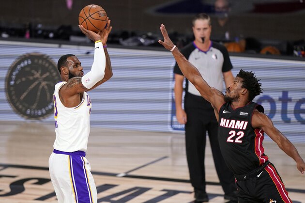 Los Angeles Lakers' LeBron James (23) shoots over Miami Heat's Jimmy Butler (22) during the first half in Game 6 of basketball's NBA Finals Sunday, Oct. 11, 2020, in Lake Buena Vista, Fla. (AP Photo/Mark J. Terrill)