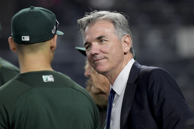 Oakland Athletics minority owner and executive vice president Billy Beane, right, talks with players before the American League wildcard playoff baseball game against the New York Yankees, Wednesday, Oct. 3, 2018, in new York (AP Photo/Bill Kostroun)