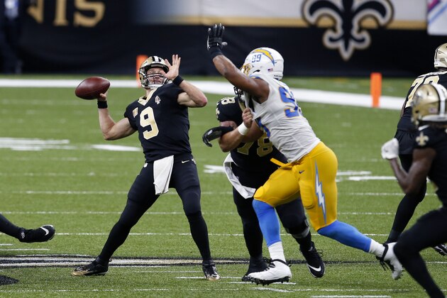 New Orleans Saints quarterback Drew Brees (9) throws a touchdown pass to tight end Jared Cook, not pictured, under pressure from Los Angeles Chargers defensive tackle Jerry Tillery (99) in the second half of an NFL football game in New Orleans, Monday, Oct. 12, 2020. (AP Photo/Butch Dill)