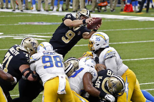 El quarterback de los Saints de Nueva Orleans Drew Brees (9) salta por encima de la línea de gol para un tourchdown en la primera mitad de su juego de NFL contra los Chargers de Los Ángeles en Nueva Orleans, el lunes 12 de octubre de 2020. (AP Foto/Butch Dill)