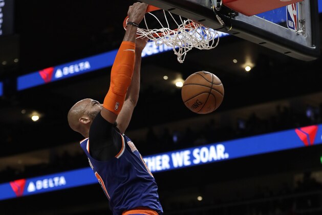 New York Knicks center Taj Gibson (67) scores as Atlanta Hawks guard Kevin Huerter (3) looks on during the second half of an NBA basketball game Wednesday, March 11, 2020, in Atlanta. (AP Photo/John Bazemore)