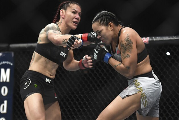 Cris Cyborg, left, and Amanda Nunes exchange punches during the first round of a featherweight mixed martial arts bout at UFC 232, Saturday, Dec. 29, 2018, in Inglewood, Calif. (AP Photo/Kyusung Gong)