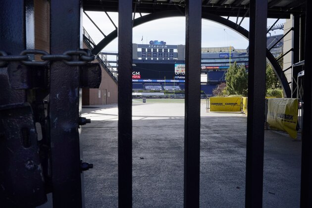 The Gillette Stadium logo, behind, stands above an empty field at the stadium that is home to the New England Patriots football team, Sunday, Oct. 11, 2020, in Foxborough, Mass. The NFL has postponed the Denver Broncos-New England Patriots game due to another positive coronavirus test with the Patriots. (AP Photo/Steven Senne)