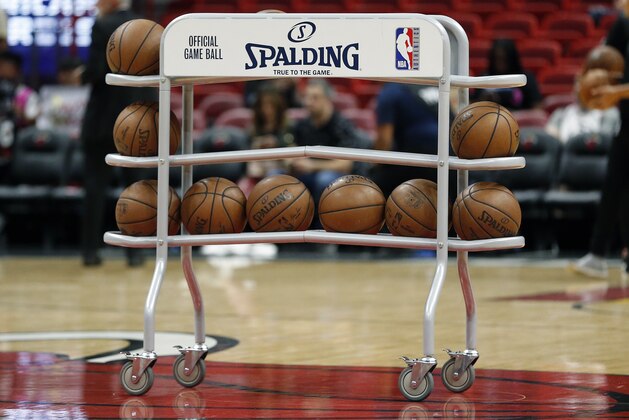 A rack of NBA Spading basketballs sit at mid court prior to the start of an NBA basketball game between the Miami Heat and the Dallas Mavericks, Thursday, March 28, 2019, in Miami. The Heat defeated the Mavericks 105-99. (AP Photo/Joel Auerbach)