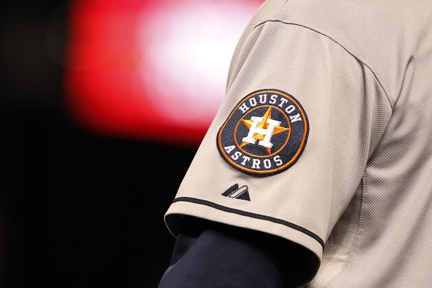 Houston Astros logo shines off sleeve of first base coach Dave Clark in the ninth inning of Astros' 6-3 victory over the Colorado Rockies in a baseball game in Denver on Wednesday, May 29, 2013. (AP Photo/David Zalubowski)
