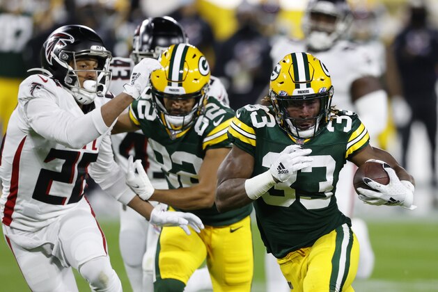 Green Bay Packers' Aaron Jones (33) is chased by Atlanta Falcons' Isaiah Oliver (26) during the first half of an NFL football game, Monday, Oct. 5, 2020, in Green Bay, Wis. (AP Photo/Tom Lynn)