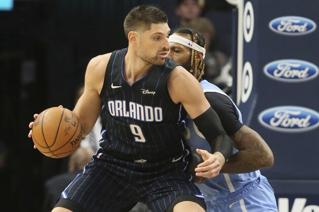 FILE - In this March 6, 2020, file photo, Orlando Magic's Nikola Vucevic, left, works his way around Minnesota Timberwolves' James Johnson in the second half of an NBA basketball game in Minneapolis. The Magic enter the NBA restart trying to clinch an Eastern Conference playoff berth. (AP Photo/Jim Mone, File)