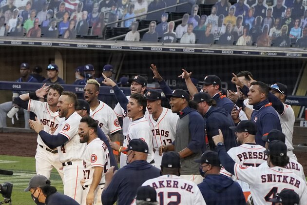 CORRECTS TO THURSDAY, OCT. 15, 2020, NOT TUESDAY, DEC. 15, 2020 - Players celebrate Houston Astros Carlos Correa's walk off home run during the ninth inning in Game 5 of a baseball American League Championship Series, Thursday, Oct. 15, 2020, in San Diego. The Astros defeated the Rays 4-3 and the Rays lead the series 3-2 games. (AP Photo/Ashley Landis)