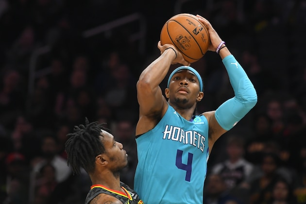 Charlotte Hornets guard Devonte' Graham (4) shoots as Atlanta Hawks guard Treveon Graham defends during overtime in an NBA basketball game Monday, March 9, 2020, in Atlanta. (AP Photo/John Amis)