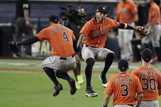 Houston Astros George Springer (4) and Carlos Correa celebrate after Game 6 of a baseball American League Championship Series against the Tampa Bay Rays, Friday, Oct. 16, 2020, in San Diego. The Astros defeated the Rays 7-4 to tie the series 3-3. (AP Photo/Jae C. Hong)