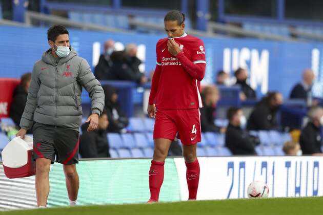 Liverpool's Virgil van Dijk leaves the match with an injury during the English Premier League soccer match between Everton and Liverpool at Goodison Park stadium, in Liverpool, England, Saturday, Oct. 17, 2020. (Cath Ivill/Pool via AP)