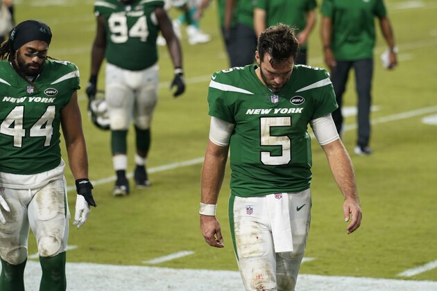 New York Jets quarterback Joe Flacco (5) and linebacker Harvey Langi (44) walk off the field during the end of an NFL football game against the Miami Dolphins, Sunday, Oct. 18, 2020, in Miami Gardens, Fla. The Dolphins defeated the Jets 24-0. (AP Photo/Lynne Sladky)