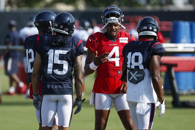 Houston Texans quarterback Deshaun Watson (4) talks to wide receivers Kenny Stills (12), Will Fuller V (15), and Randall Cobb (18) during an NFL training camp football practice Sunday, Aug. 23, 2020, in Houston. (Brett Coomer/Houston Chronicle via AP, Pool)