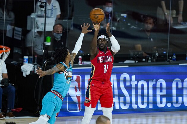 New Orleans Pelicans' Jrue Holiday (11) shoots over Memphis Grizzlies' Ja Morant (12) during the first half of an NBA basketball game Monday, Aug. 3, 2020 in Lake Buena Vista, Fla. (AP Photo/Ashley Landis, Pool)