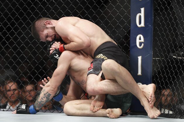 Khabib Nurmagomedov, top, applies a rear naked choke hold to Conor McGregor during a lightweight title mixed martial arts bout at UFC 229 in Las Vegas, Saturday, Oct. 6, 2018. Nurmagomedov won the fight by submission during the fourth round to retain the title. (AP Photo/John Locher)