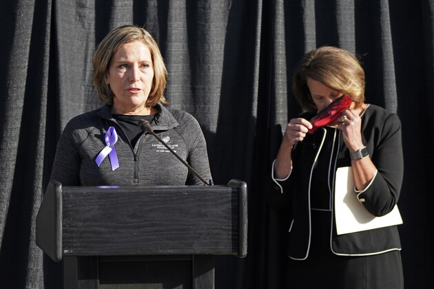 University of Utah President Ruth Watkins, right, puts on her mask as Jill McCluskey, the mother of slain University of Utah student-athlete Lauren McCluskey speaks during a press conference announcing they have reached a settlement in their lawsuit against the university Thursday, Oct. 22, 2020, in Salt Lake City. (AP Photo/Rick Bowmer) University of Utah President Ruth Watkins, right, puts on her mask as Jill McCluskey, the mother of slain University of Utah student-athlete Lauren McCluskey speaks during a press conference announcing they have reached a settlement in their lawsuit against the university Thursday, Oct. 22, 2020, in Salt Lake City. (AP Photo/Rick Bowmer)