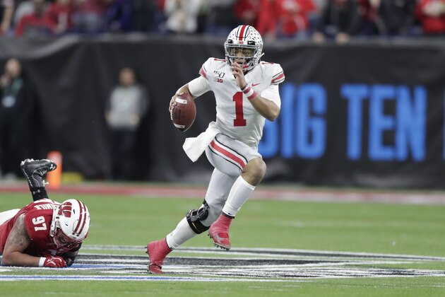 Ohio State quarterback Justin Fields (1) runs with the ball past Wisconsin defensive end Isaiahh Loudermilk during the first half of the Big Ten championship NCAA college football game, Saturday, Dec. 7, 2019, in Indianapolis. (AP Photo/Michael Conroy)