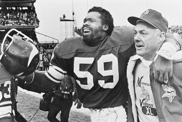 Vikings coach Bud Grant breaks into a rare on-field smile as he heads toward the dressing room with linebacker Matt Blair after Minnesota's last-second 28-23 victory over the Cleveland Browns in Bloomington, Minn., Dec. 14, 1980. (AP Photo)