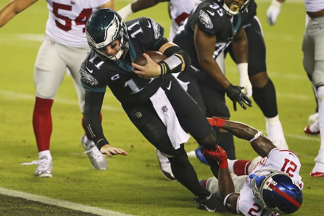 Philadelphia Eagles' Carson Wentz (11) as tackled New York Giants' Gabriel Peppers (21) as he scores a rushing touchdown during the first half of an NFL football game, Thursday, Oct. 22, 2020, in Philadelphia. (AP Photo/Rich Schultz)