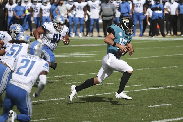 Jacksonville Jaguars quarterback Gardner Minshew II, right, scrambles past the Detroit Lions defense for a 6-yard touchdown during the second half of an NFL football game, Sunday, Oct. 18, 2020, in Jacksonville, Fla. (AP Photo/Stephen B. Morton)