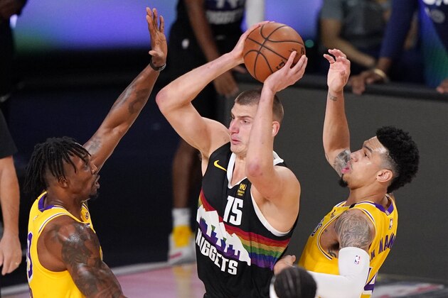 Denver Nuggets' Nikola Jokic (15) is defended by Los Angeles Lakers' Dwight Howard, left, and Danny Green (14) during the first half of an NBA conference final playoff basketball game Thursday, Sept. 24, 2020, in Lake Buena Vista, Fla. (AP Photo/Mark J. Terrill)