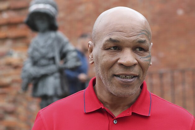 Mike Tyson, an American former heavyweight boxing champion, stands in front of a memorial to Polish suffering during World War II, during a visit to Warsaw, Poland, on Thursday June 27, 2019. (AP Photo/Czarek Sokolowski)