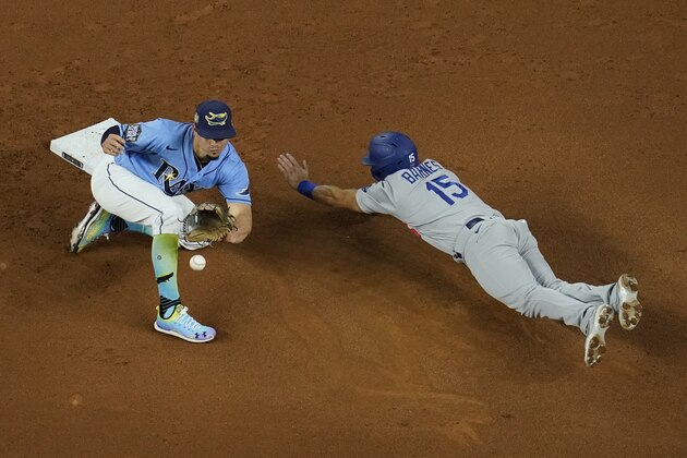 Los Angeles Dodgers' Austin Barnes gets caught stealing by Tampa Bay Rays shortstop Willy Adames during the second inning in Game 5 of the baseball World Series Sunday, Oct. 25, 2020, in Arlington, Texas. (AP Photo/David J. Phillip)
