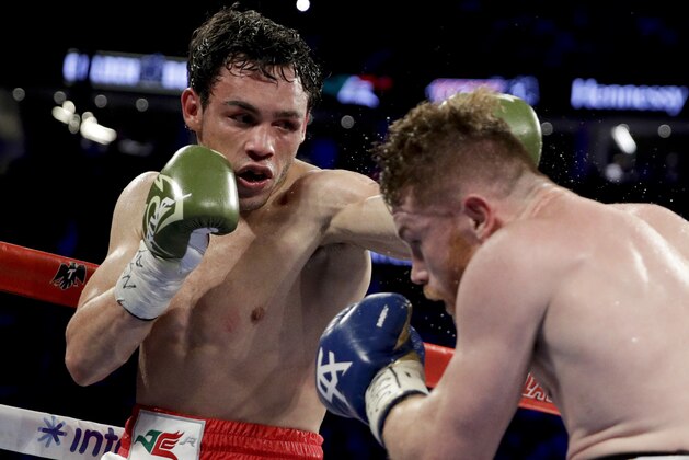 Canelo Alvarez, right, of Mexico, gets hit by Julio Cesar Chavez Jr., of Mexico, during their catch weight boxing match, Saturday, May 6, 2017, in Las Vegas. (AP Photo/John Locher)