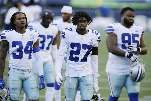 Dallas Cowboys' Rico Dowdle (34), Trevon Diggs (27), and Dontari Poe (95) walk off the field after an NFL football game against the Seattle Seahawks, Sunday, Sept. 27, 2020, in Seattle. The Seahawks won 38-31. (AP Photo/John Froschauer)