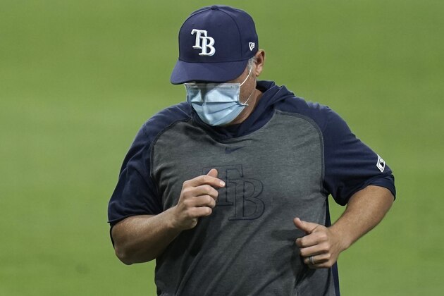 Tampa Bay Rays manager Kevin Cash wears a mask as he walks back to the dugout after a pitching change during the eighth inning in Game 4 of a baseball American League Division Series against the New York Yankees, Thursday, Oct. 8, 2020, in San Diego. The Yankees won 5-1. (AP Photo/Jae C. Hong)