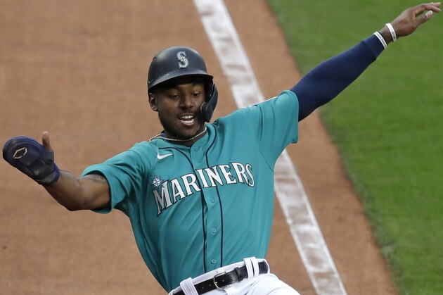 Seattle Mariners' Kyle Lewis slides into home plate in the fourth inning of a baseball game during the Mariners home opener Friday, July 31, 2020, in Seattle. (AP Photo/Elaine Thompson)