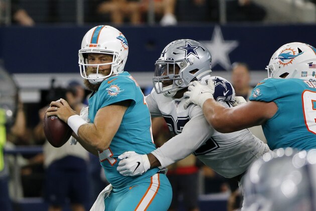 Miami Dolphins quarterback Ryan Fitzpatrick, left, attempts to throw a pass under pressure from Dallas Cowboys' Dorance Armstrong (92) in the first half of an NFL football game in Arlington, Texas, Sunday, Sept. 22, 2019. (AP Photo/Michael Ainsworth)
