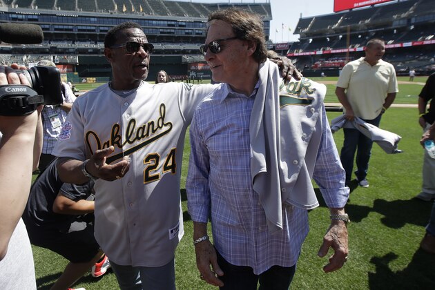 Former Oakland Athletics player Rickey Henderson, left, walks with former manager Tony La Russa before a baseball game between the Athletics and the San Francisco Giants in Oakland, Calif., Sunday, Aug. 25, 2019. (AP Photo/Jeff Chiu)