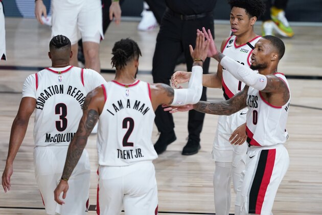 Portland Trail Blazers guard Damian Lillard (0) celebrates with teammates during the first half of an NBA basketball first round playoff game against the Los Angeles Lakers, Saturday, Aug. 22, 2020, in Lake Buena Vista, Fla. (AP Photo/Ashley Landis, Pool)