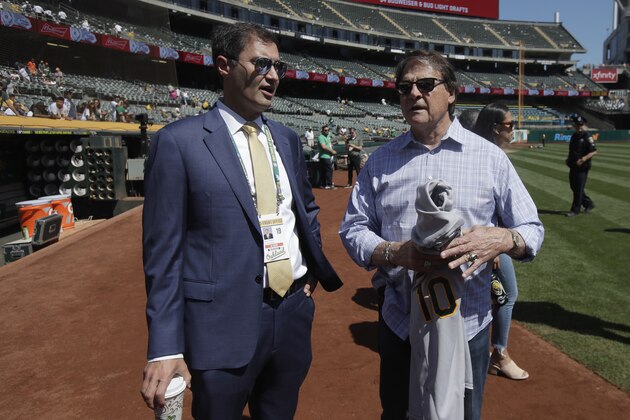 Oakland Athletics President Dave Kaval, left, talks with former manager Tony La Russa before a baseball game between the Athletics and the San Francisco Giants in Oakland, Calif., Sunday, Aug. 25, 2019. (AP Photo/Jeff Chiu)