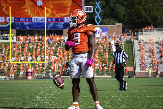 Clemson running back Travis Etienne (9) spins the ball out of his hands after scoring a touchdown during an NCAA college football game against Syracuse in Clemson, S.C., on Saturday, Oct. 24, 2020. (Ken Ruinard/Pool Photo via AP)