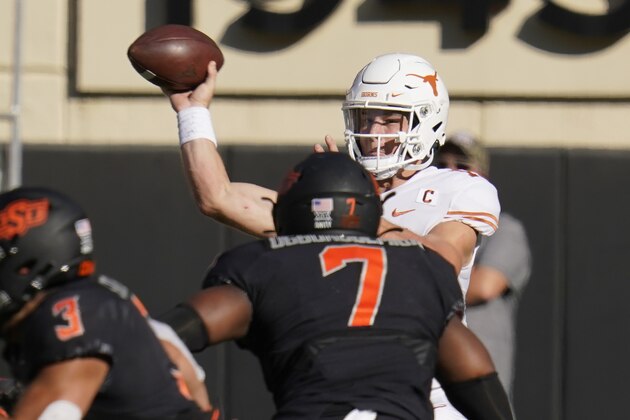 Texas quarterback Sam Ehlinger throws under pressure from Oklahoma State linebacker Amen Ogbongbemiga (7) during the first half of an NCAA college football game in Stillwater, Okla., Saturday, Oct. 31, 2020. (AP Photo/Sue Ogrocki)