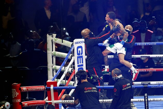 Gervonta Davis, top center, celebrates with his corner after knocking out Leo Santa Cruz, lower left, in the sixth round of a WBA super featherweight and WBA lightweight boxing bout Saturday, Oct. 31, 2020, in San Antonio. (AP Photo/Ronald Cortes)