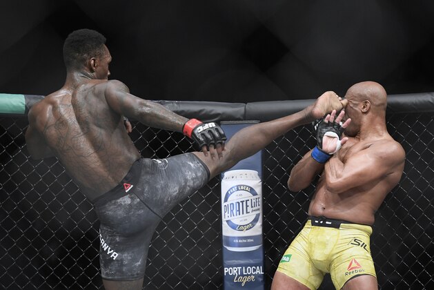 Nigeria's Israel Adesanya, left,  kicks Brazil's Anderson Silva during their middleweight bout at the UFC 234 event in Melbourne, Australia, Sunday, Feb. 10, 2019. (AP Photo/Andy Brownbill)