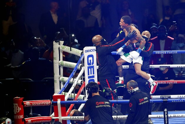 Gervonta Davis, top center, celebrates with his corner after knocking out Leo Santa Cruz, lower left, in the sixth round of a WBA super featherweight and WBA lightweight boxing bout Saturday, Oct. 31, 2020, in San Antonio. (AP Photo/Ronald Cortes)