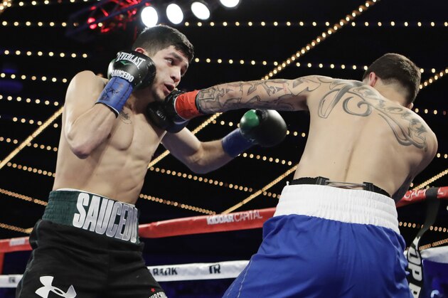 Alex Saucedo, of Mexico, left, punches Johnny Garcia, during the first round of a super lightweight boxing match Friday, March 17, 2017, in New York. Saucedo stopped Garcia in the second round.(AP Photo/Frank Franklin II)