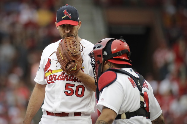 St. Louis Cardinals starting pitcher Adam Wainwright, left, talks with catcher Yadier Molina, right, during the fourth inning in Game 3 of a National League Division Series against the Atlanta Braves, Sunday, Oct. 6, 2019, in St. Louis. (AP Photo/Charlie Riedel)
