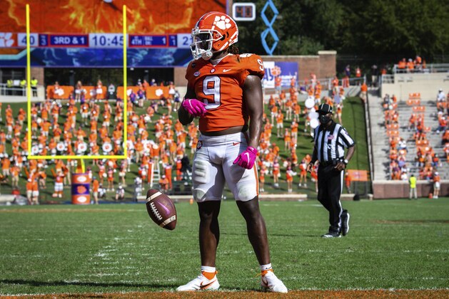 Clemson running back Travis Etienne (9) spins the ball out of his hands after scoring a touchdown during an NCAA college football game against Syracuse in Clemson, S.C., on Saturday, Oct. 24, 2020. (Ken Ruinard/Pool Photo via AP)