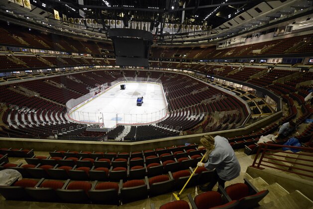 Workers clean up after an NHL hockey game between the Chicago Blackhawks and the San Jose Sharks at The United Center Wednesday, March 11, 2020, in Chicago. (AP Photo/Paul Beaty)