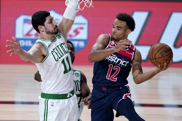 Washington Wizards' Jerome Robinson (12) looks to pass around Boston Celtics' Enes Kanter (11) during the first half of an NBA basketball game Thursday, Aug. 13, 2020 in Lake Buena Vista, Fla. (AP Photo/Ashley Landis, Pool)