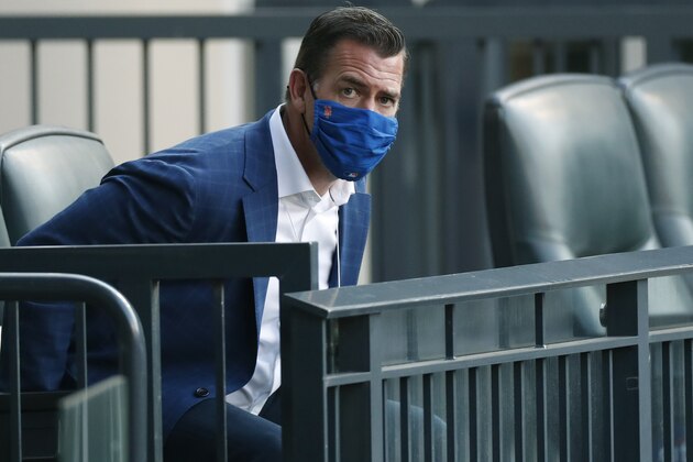 New York Mets general manager Brodie Van Wagenen eyes a group of photographers as he takes a seat before a baseball game between the Mets and the Washington Nationals, Monday, Aug. 10, 2020, in New York. (AP Photo/Kathy Willens)