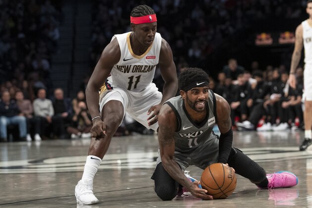 Brooklyn Nets guard Kyrie Irving, right, and New Orleans Pelicans guard Jrue Holiday vie for a loose ball during the first half of an NBA basketball game, Monday, Nov. 4, 2019, in New York. (AP Photo/Mary Altaffer)