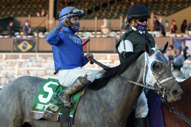 Jockey Luis Saez and Essential Quality are led to the winner's circle after winning the Breeders' Cup Juvenile horse race at Keeneland Race Course, Friday, Nov. 6, 2020, in Lexington, Ky.  (AP Photo/Michael Conroy)