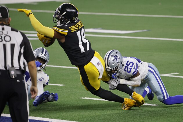 Pittsburgh Steelers wide receiver JuJu Smith-Schuster (19) dives into the end zone after catching a touchdown pass as Dallas Cowboys safety Xavier Woods (25) attempts the stop in the second half of an NFL football game in Arlington, Texas, Sunday, Nov. 8, 2020. (AP Photo/Ron Jenkins)